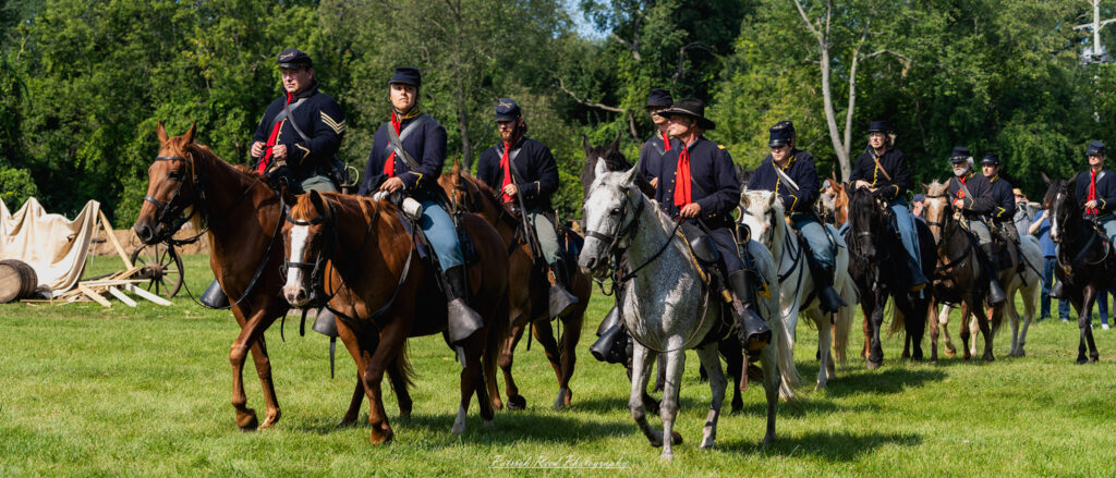 A group of Union cavalry soldiers, mounted on horseback and dressed in their distinctive blue uniforms. They display camaraderie and readiness as they prepare for action, embodying the spirit and valor of the Union forces during the Civil War.